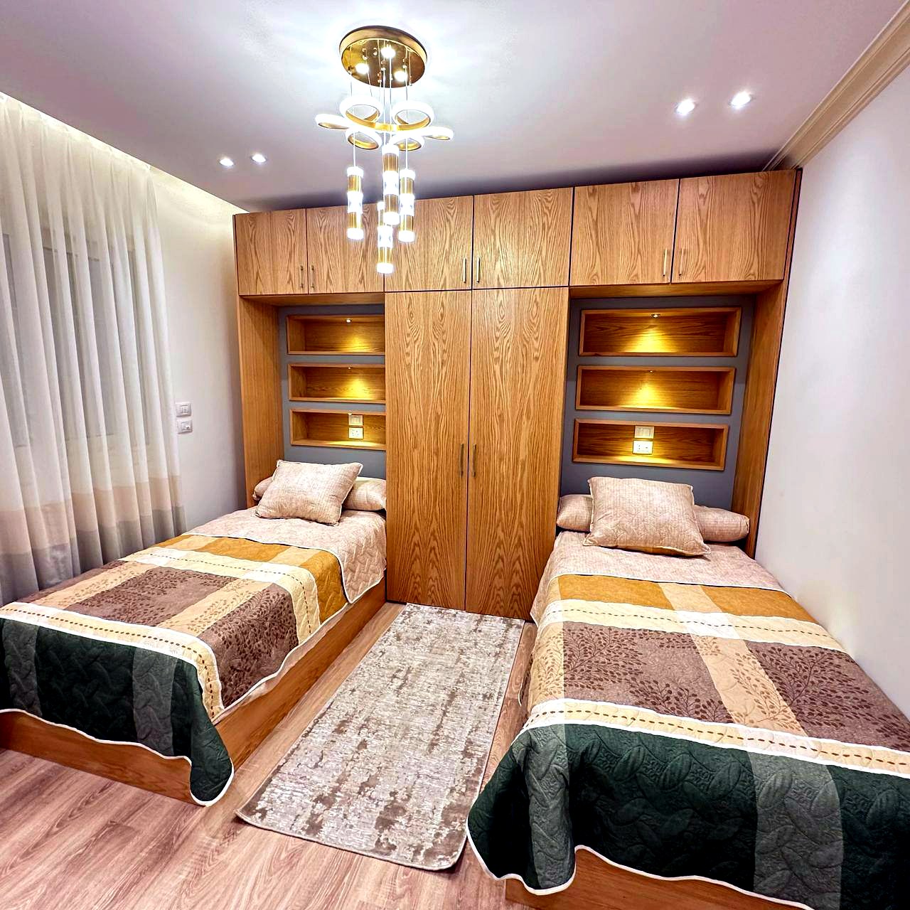 Chambre à deux lits avec rangements en bois